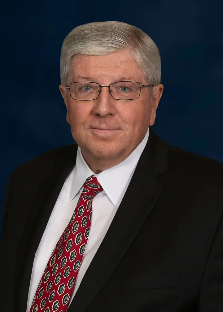 Man in glasses wearing suit and patterned tie