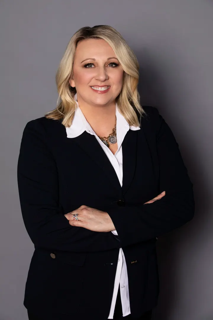 Woman in business attire, arms crossed