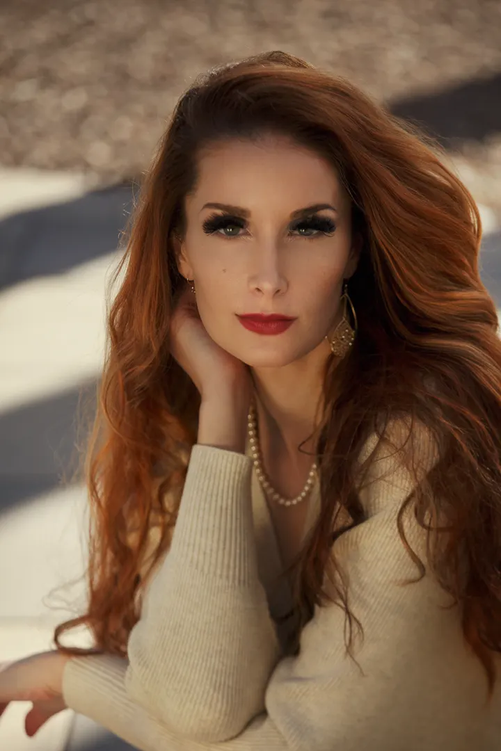 Woman with red hair and pearl necklace