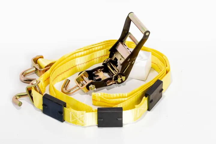 Yellow ratchet tie-down strap on white background